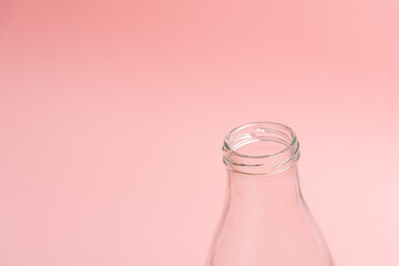 Glass bottle on the lower right thirds over pink