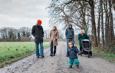 Multi-generational family walking on footpath