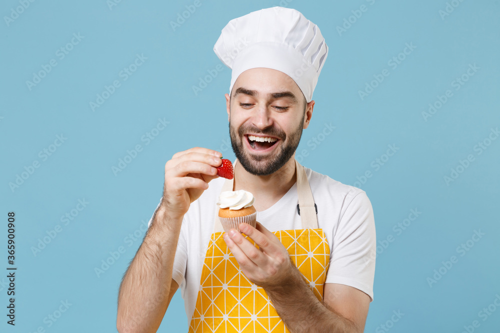 Wall mural funny young bearded male chef or cook baker man in apron white t-shirt toque chefs hat isolated on b