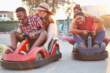Group of multietnic friends having fun with go kart  - Young people with face mask on smiling and...