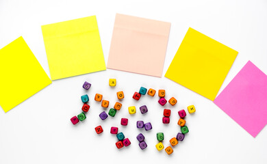 Set of colorful note stickers and latin alphabet letters on white background.