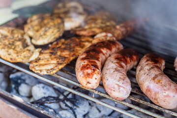 Grilling sausages and meat on a barbecue grill.
