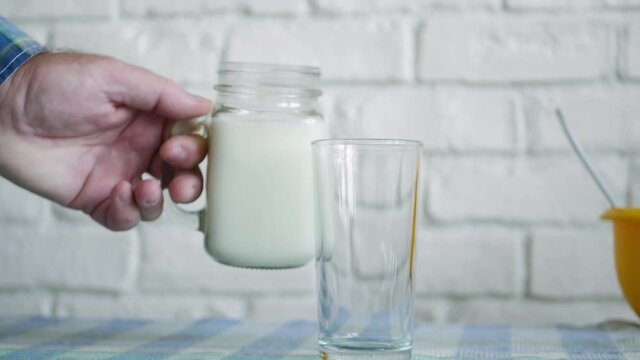 One Person Fill a Glass with Fresh Milk for Breakfast a Healthy, Tasty and Natural Drink Full with Protein and Vitamins