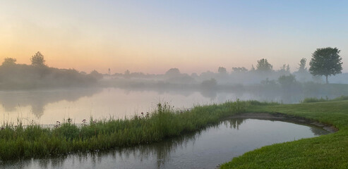Fototapeta premium sunrise foggy morning on the golf course pond reflections