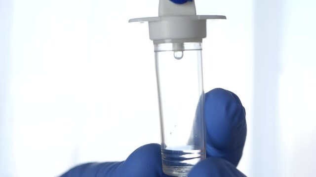 Nurse Hand Protected by the Glove Setting the Drops of a Medical Perfusion in a Hospital