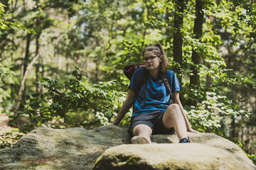 girl on an rock in a forest in blue sportsweare