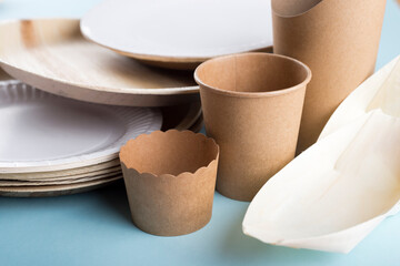 Biodegradable disposable dishes on light blue background. Recycling concept