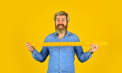 school lesson items. mature bearded man hold measuring ruler. study at home. education. school...