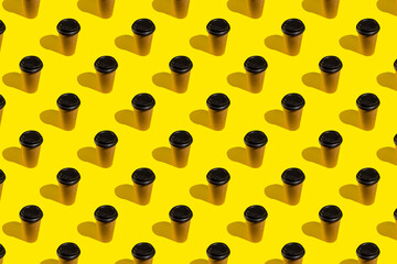 Take out coffee in brown thermo cup on bright yellow background. Coffee cup on yellow abstract pattern