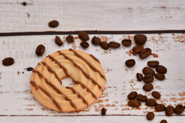 Gebäckstück mit Schokolade und Kaffeebohnen auf abstraktem Hintergrund.