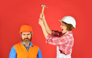 Couple making repair at home. Home Renovation. Rub in. Couple knocking head with hammer. Clearly explain. Intelligibly concept. Couple renovating apartment together. Man and woman wear safety helmet