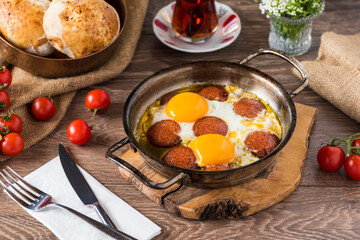 Traditional Turkish Breakfast - Fried Egg with Turkish sausage. Bread, tomato and Tea