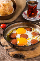Traditional Turkish Breakfast - Fried Egg with Turkish sausage. Bread, tomato and Tea