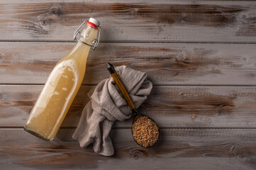 Top view homemade tradishional russian light rye kvass in bottle and linen napkin on wooden...