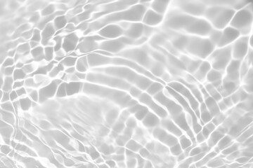 Fototapeta na wymiar Closeup of desaturated transparent clear calm water surface texture with splashes and bubbles. Trendy abstract nature background. White-grey water waves in sunlight.