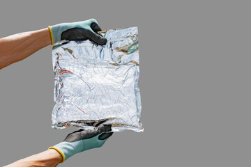 A worker is holding a packaging bag made of a material with foil