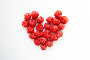 Juicy raspberries heart shaped composition isolated on white background