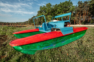 old iron catamaran stands on the shore.