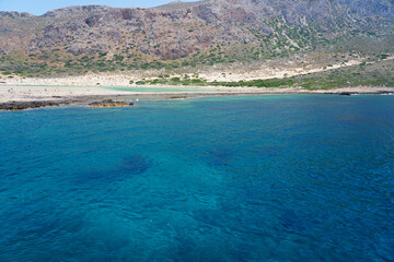 Obraz premium Blue lagoon and tropical sea coast with sandy beach among islands on sunny day with clear blue sky in Crete, Greece.