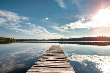 Fototapeta na wymiar Wooden pier on the background of a beautiful lake summer dawn landscape. Copy space.
