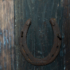 Horseshoe on a brown door background. Horseshoe for good luck. Old wooden door. Space for text....