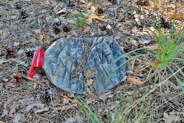 Left plastic garbage in the forest. A littered forest in Central Europe.
