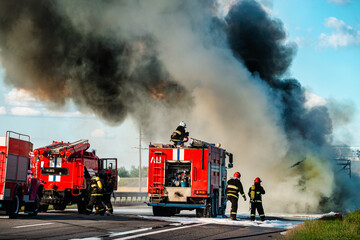 firefighter extinguishes a burning car after an accident