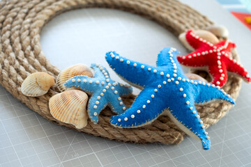 Fototapeta na wymiar DIY instruction. Step by step tutorial. Making Summer decor - wreath of rope with sea stars made of felt. Craft tools and supplies. Step 7 - Final