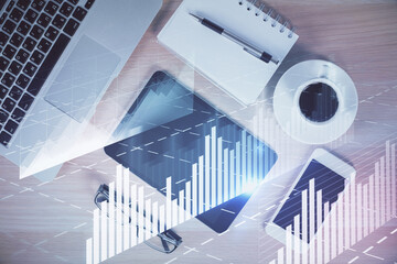 Multi exposure of forex graph hologram over desktop with phone. Top view. Mobile trade platform concept.