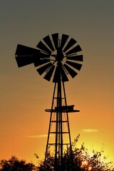windmill at sunset with a colorful sky and clouds.