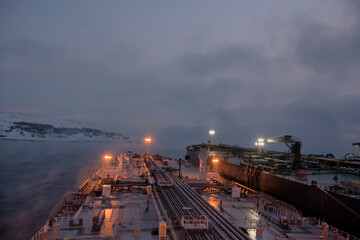 Fototapeta na wymiar STS operations in cold, arctic conditions in the early morning, 140 thousand and 300 thousand mt deadweight tankers.