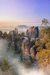 Colorful and lightful sunrise at the Bastei bridge above the Elbe River in the Elbe Sandstone Mountains of Germany. 