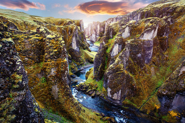 Fantastic view on picturesque canyon Fjadrargljufur with green grass and icelandic moss near river...