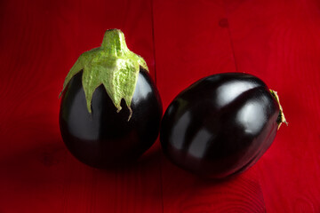 Fresh eggplants on a red wooden table