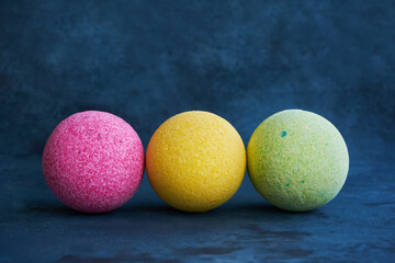 Colorful bath bombs on blue background. Copy space for text