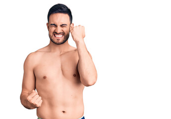 Fototapeta premium Young handsome man wearing swimwear celebrating surprised and amazed for success with arms raised and eyes closed. winner concept.