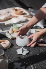 Female potter making ceramic dishes at her studio. Working process of glazing ceramic bowl.