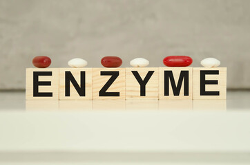  the enzyme vitamin is written on wooden cubes with tablets on cubes