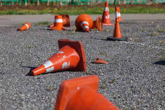 Several old traffic cones are strewn across the asphalt