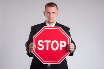 Man holding a stop sign. Stop road sign in hands of a man. Stop inscription as a symbol of stopping...
