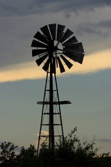 windmill at sunset in Kansas with clouds.