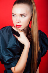 young pretty woman young lady posing on red background wearing gold jewelry, lifestyle people concept