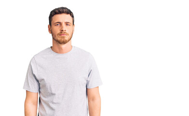 Handsome young man with bear wearing casual tshirt skeptic and nervous, frowning upset because of problem. negative person.