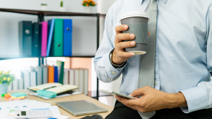 Professional Business man hand hold drink fresh coffee in paper cup glasses morning refreshing coffee break before working meeting computer smartphone mobile