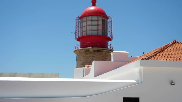 Scene with Cape of St. Vincent lighthouse on sunny day. Tilt up, slomo