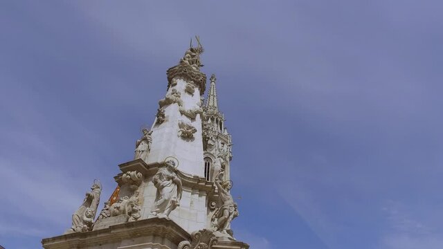 The Holy Trinity column front of the Matthias Church (Church of the Assumption of the Buda Castle) in Budapest Hungary, Europe. 4k Hand held
