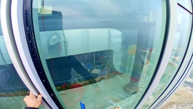 Abseiler construction worker on skyscrapper cleaning windows, point of view shot