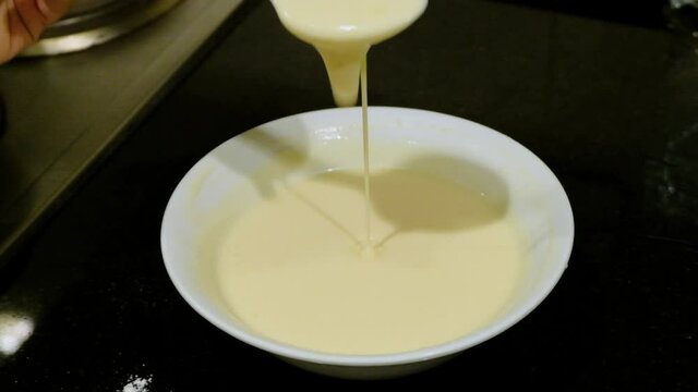 Spooning Pancake Mixture in White Bowl, Close Up