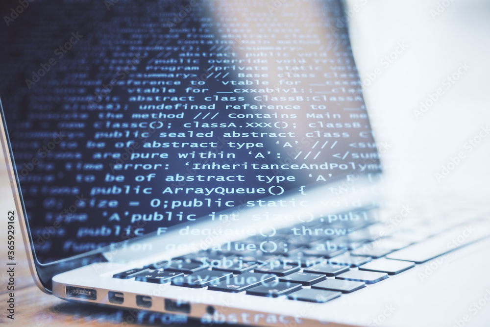 Aufkleber Laptop on table with abstract coding backdrop with text.