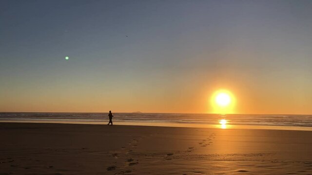 Fisherman walking by the beach during sunrise